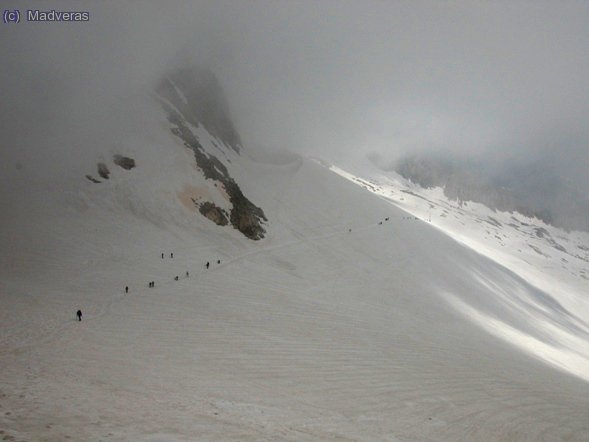 Entre la niebla se ve la procesion de la gente que empieza a subir